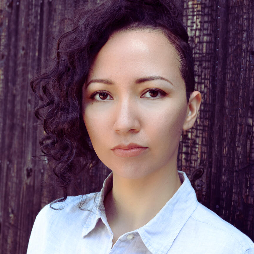 焼杉の前に立つ30代の白人系ハーフの翻訳者の写真